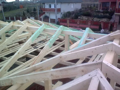 Fa tetőszerkezet gerendákkal, szarufákkal és függőleges oszlopokkal.