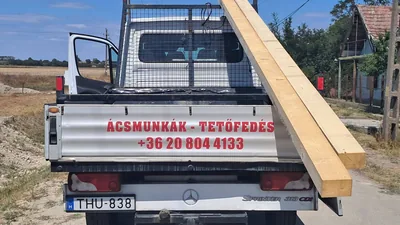 Érd – Hosszú faelemek a feliratozott ácsipari teherautón, hátulnézetből.