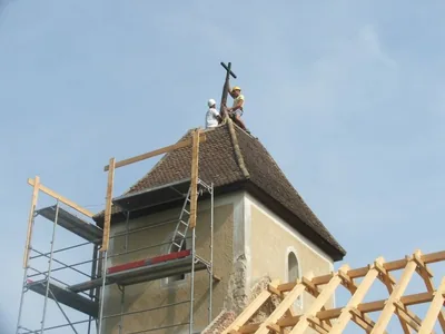 Budaörs – Szakemberek a kápolna régi toronytetőjének csúcsán, a kereszt mellett.