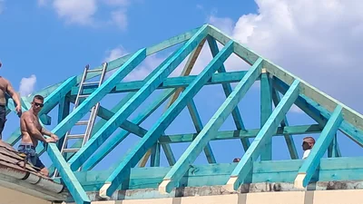 Százhalombatta – Szakemberek az új tetővázon dolgoznak, a szarufák között létrákkal.